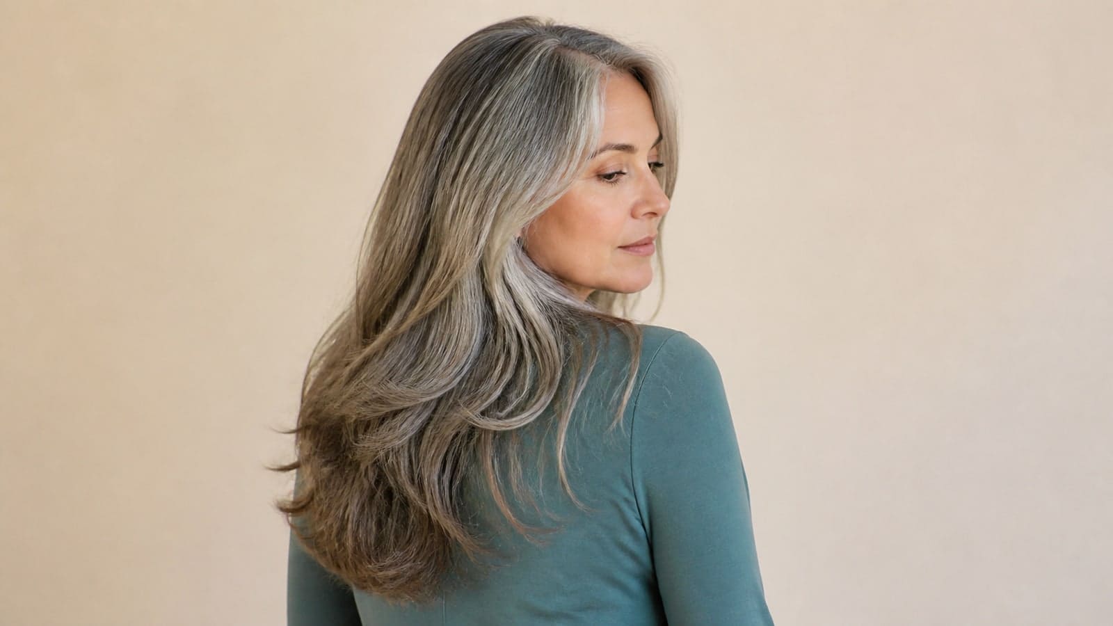 Back-three-quarter view of long silver waves with visible face-framing layers and complete chest-length ends