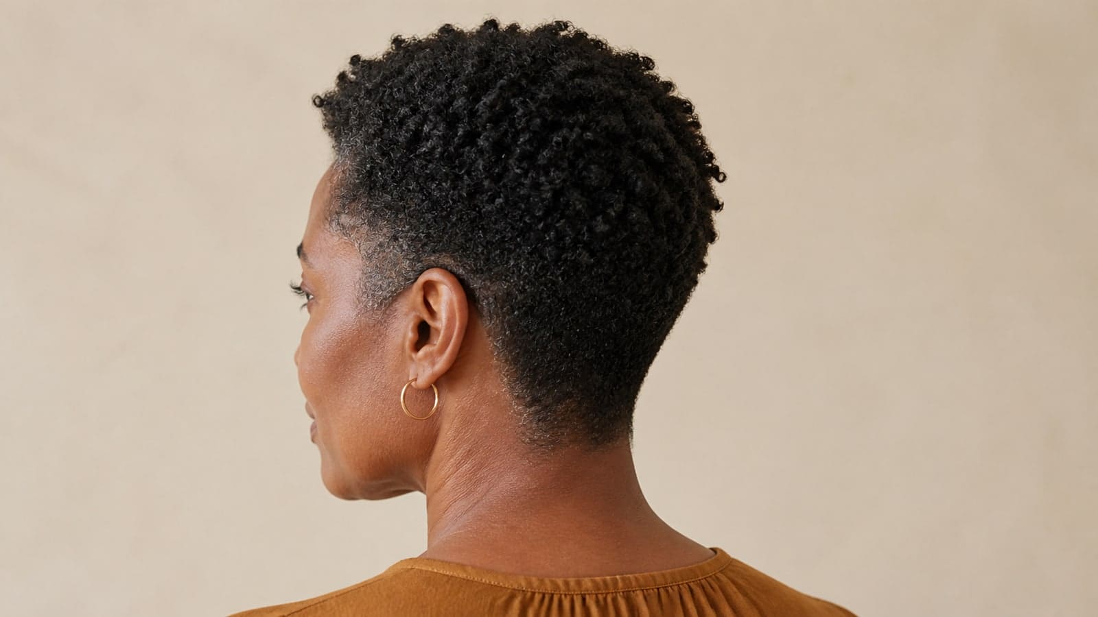 Coily tapered crop with a compact dry outline, longer crown coils, close sides, tapered nape, and short coily fringe