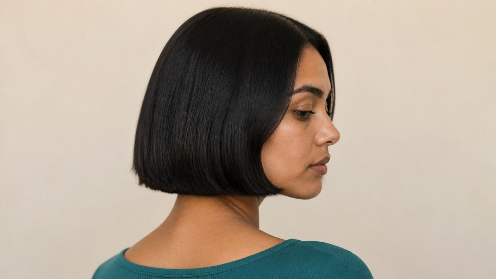 Short bob with a jaw-level blunt perimeter, compact crown, open forehead, and clean nape on straight medium-density hair